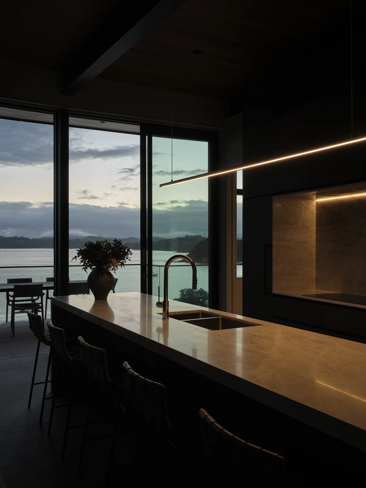 Dawn along the kitchen bar with its pendant and cooking recess illuminated