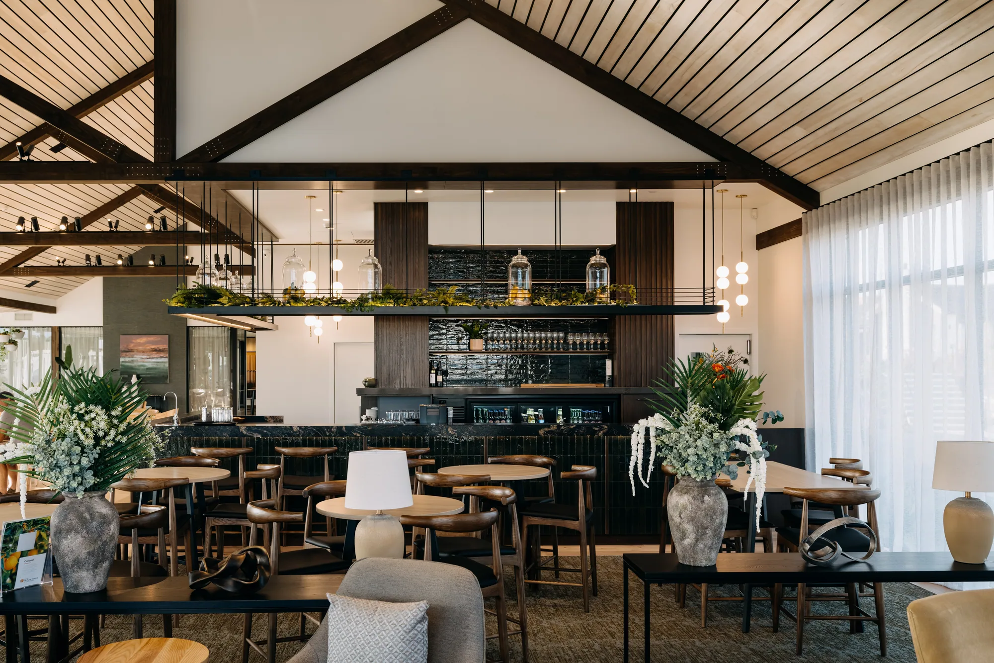 Front view of the Arvida clubhouse bar with suspended gantry, dark tile and timber joinery