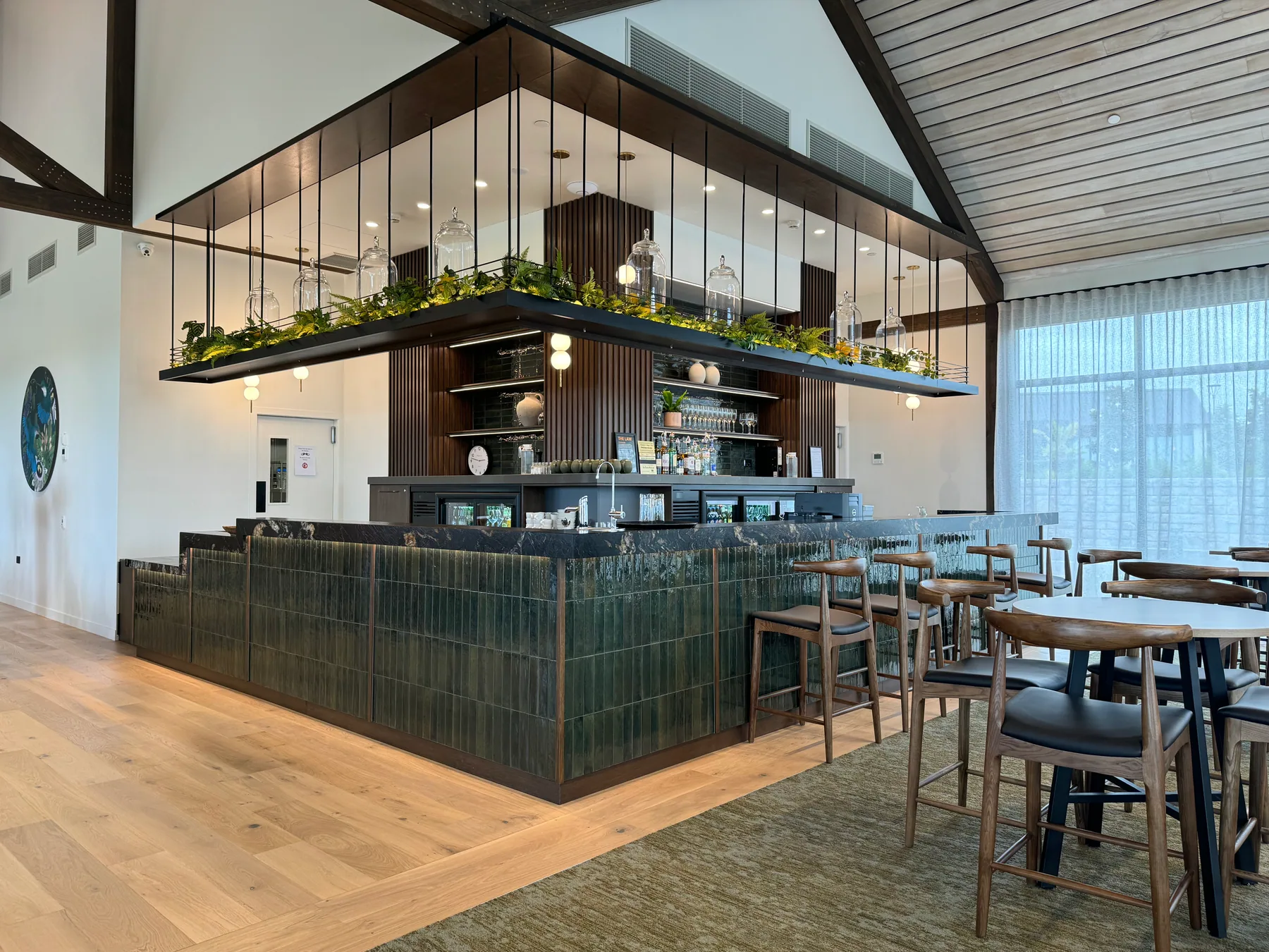 Angled view of the custom commercial bar, tiled frontage and suspended planting gantry