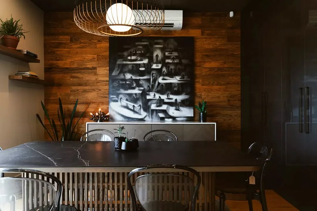 Warm commercial dining room with full-height dark cabinetry, timber wall lining and a slatted serving counter