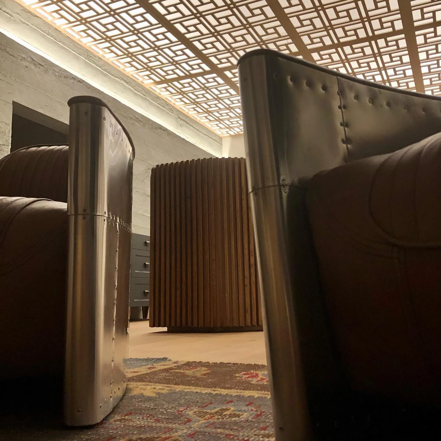 Close detail of custom timber screening and stainless furniture beside commercial booth seating
