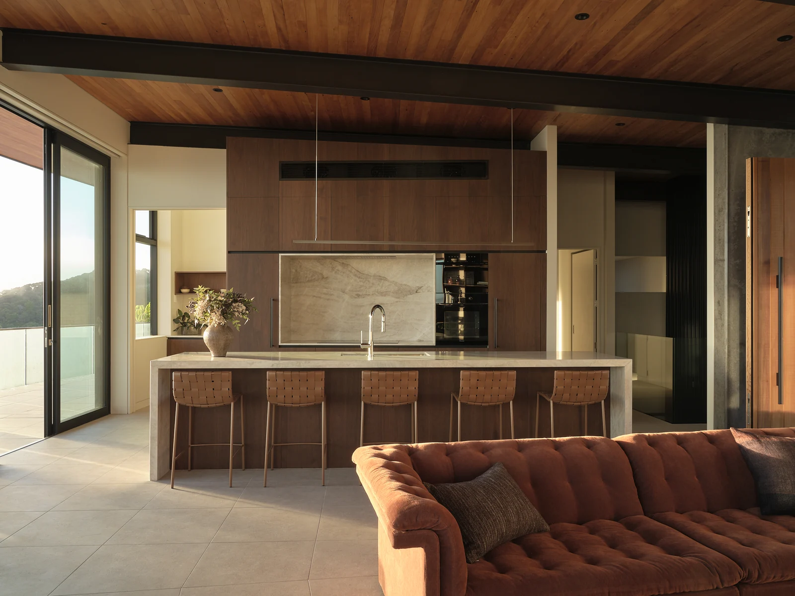 School Road kitchen in daylight with sun falling across the island and living room