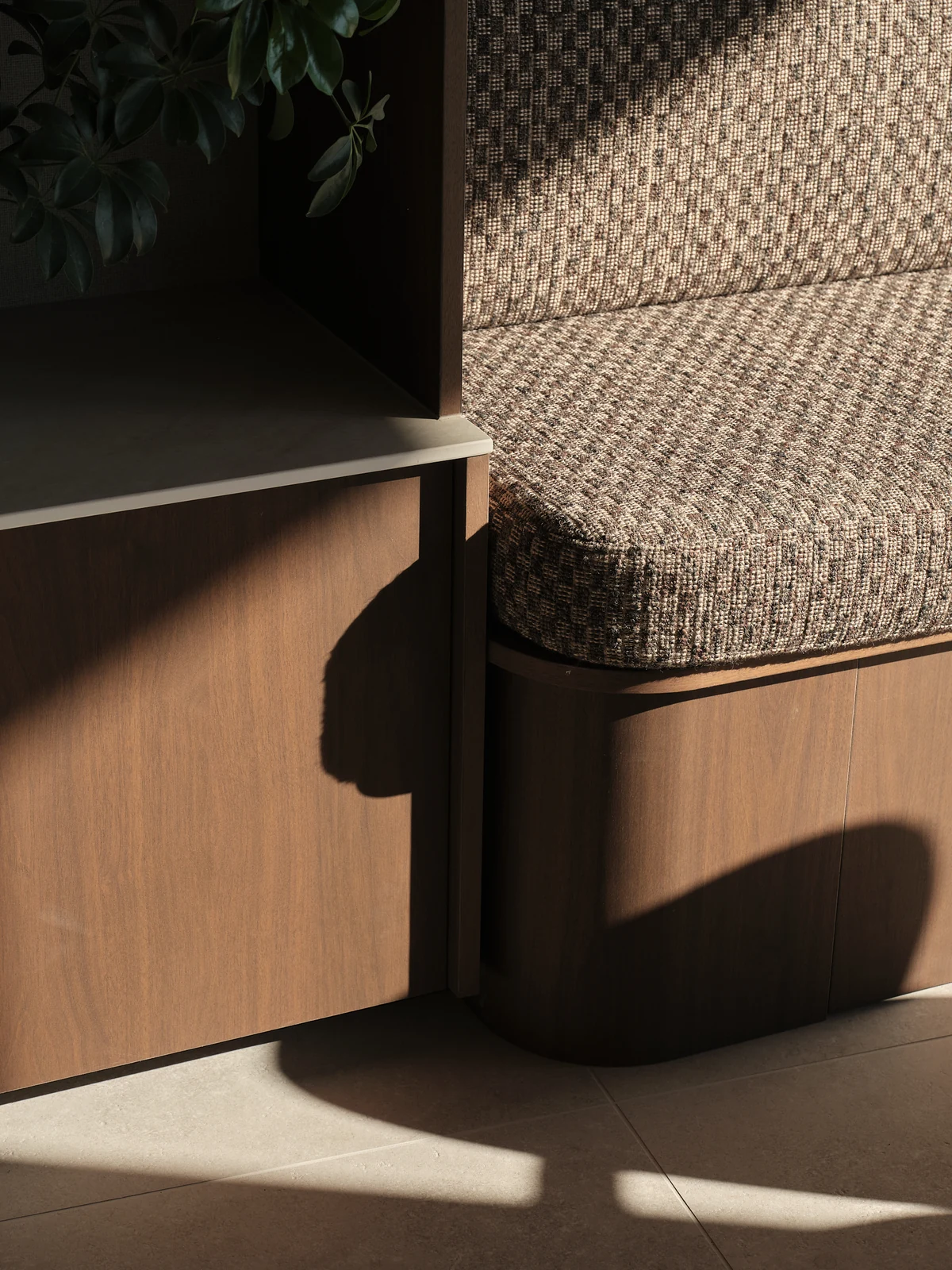Morning sunlight on the rounded end of the upholstered living window seat and timber storage below