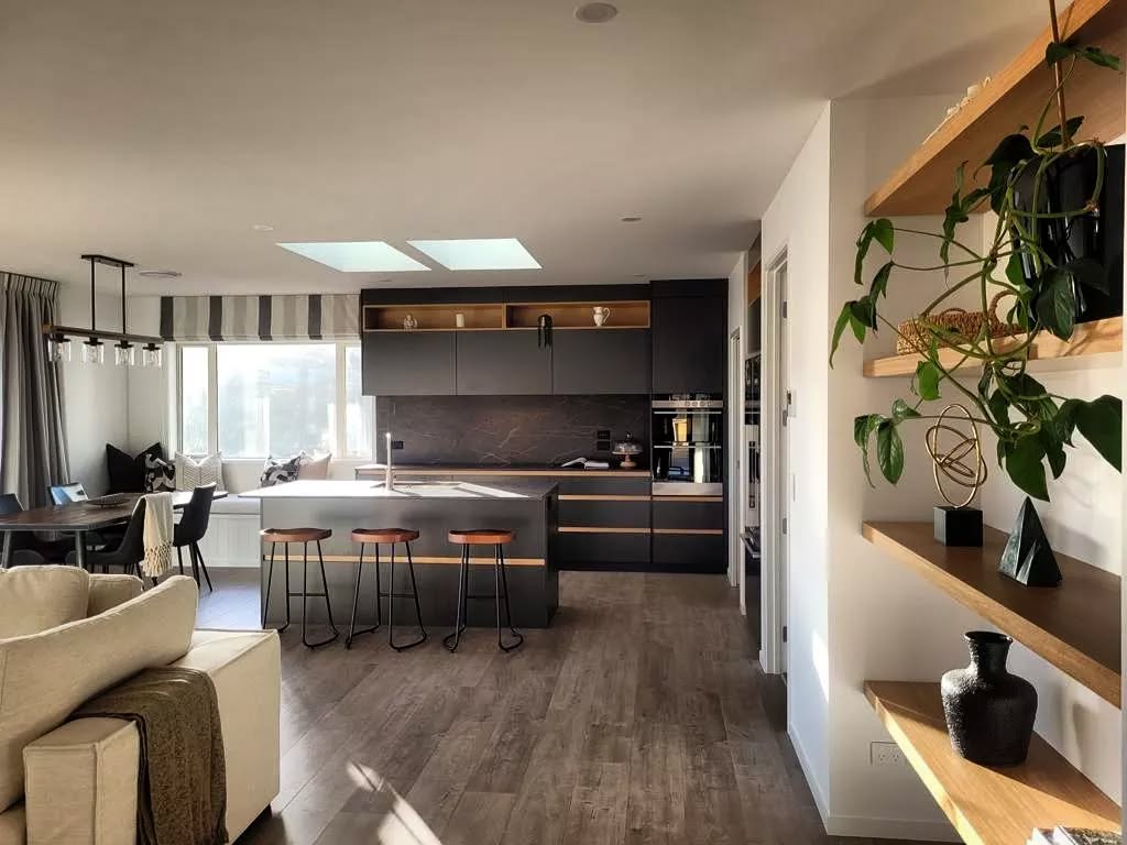Charcoal kitchen and island viewed from the adjoining living space