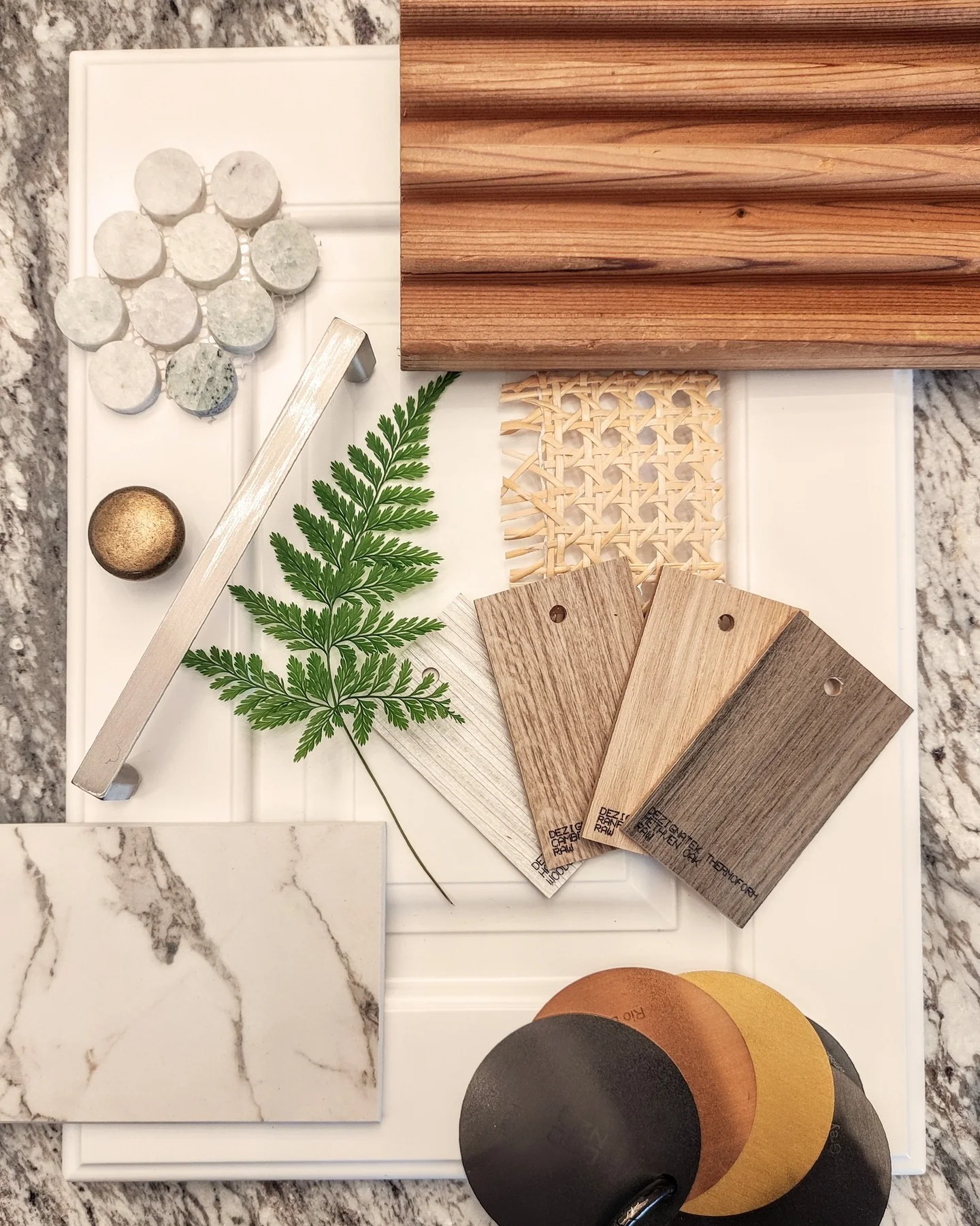 Kitchen material palette with stone, timber, cabinet colours, hardware and botanical detail