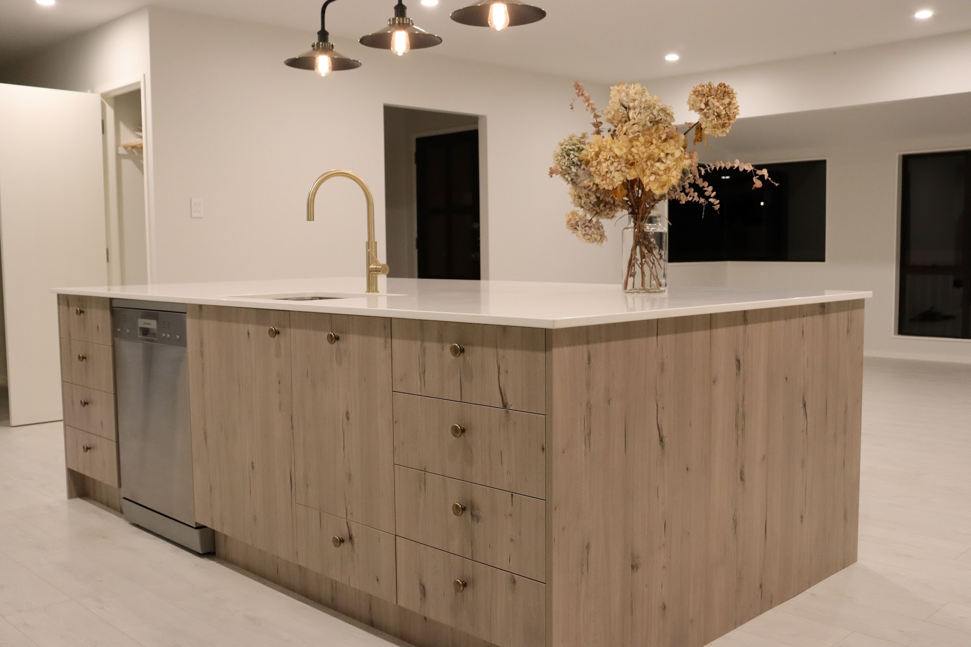 Custom oak kitchen island with integrated drawers and a white benchtop by North Interiors