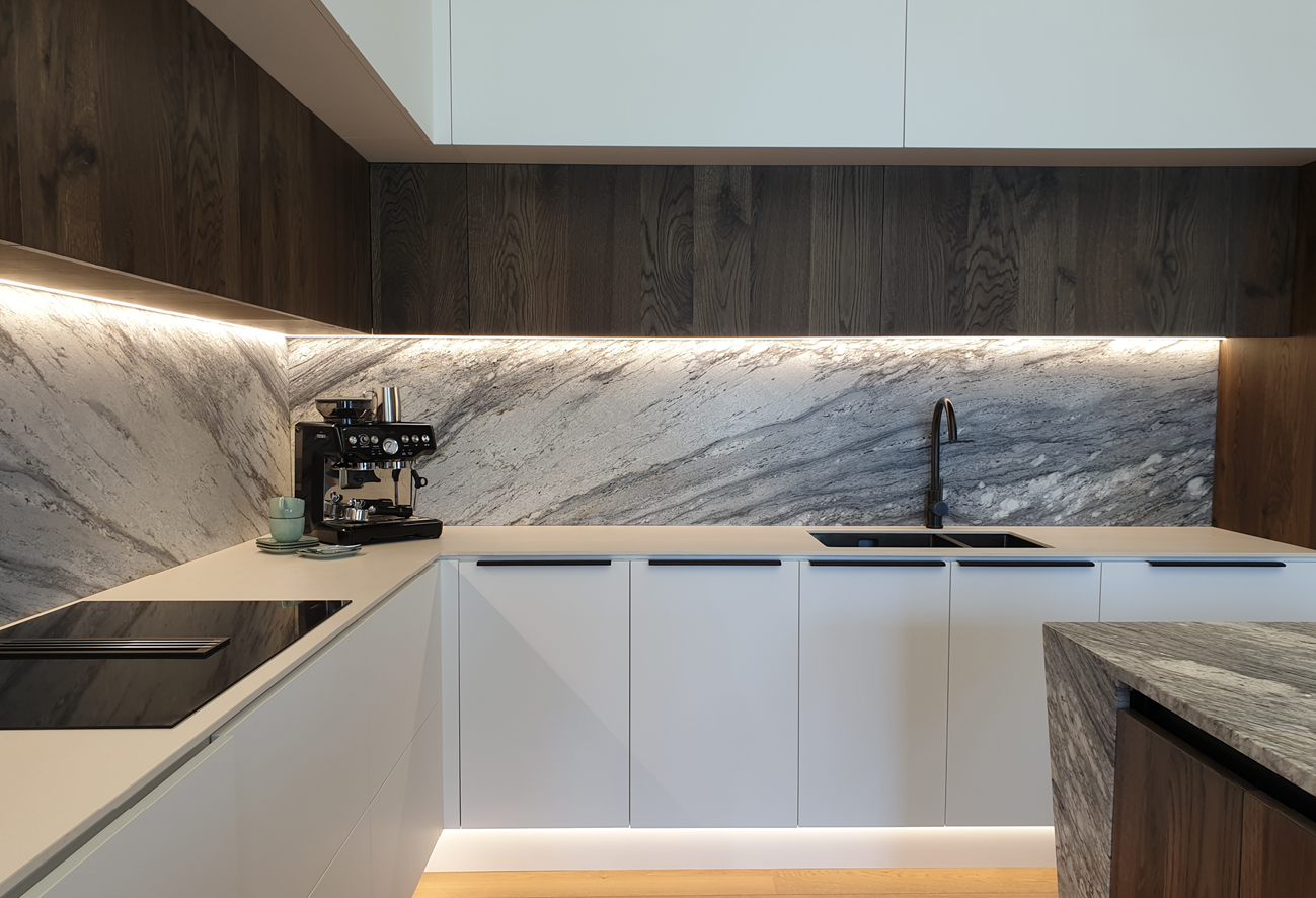 Stone splashback, timber cabinetry and integrated lighting in the North Interiors showroom kitchen