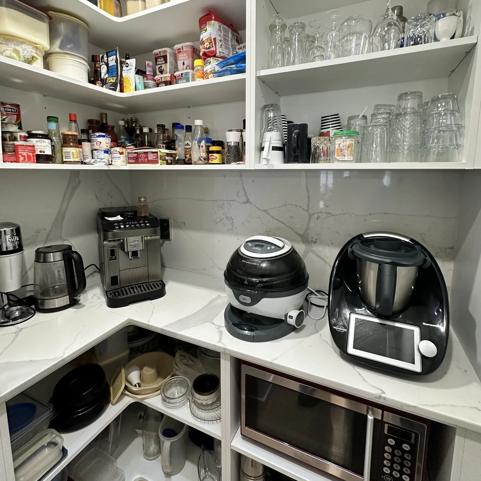 Working scullery with open appliance storage, corner worktop and shelves filled for everyday use