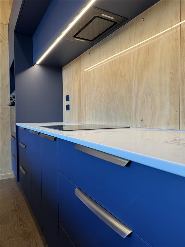 Navy scullery cabinetry with plywood splashback, integrated lighting and stainless hardware