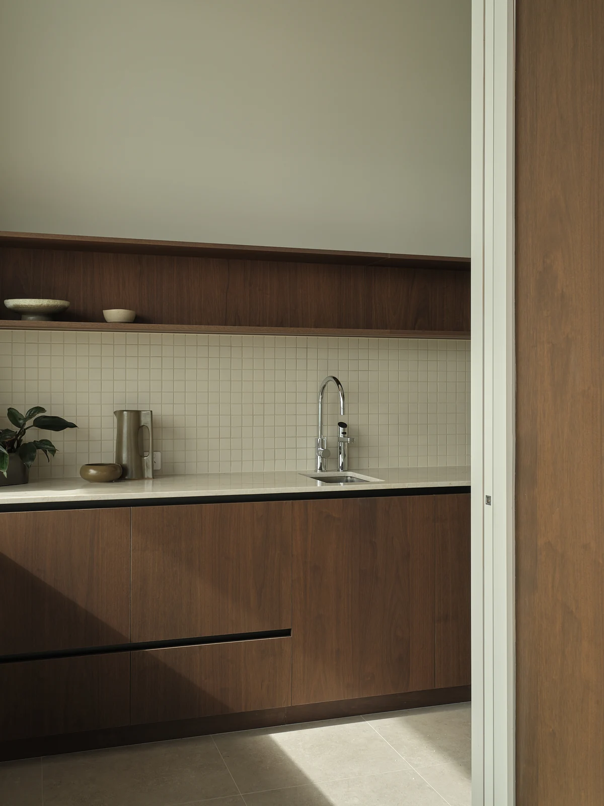 Scullery worktop with an undermounted sink, two taps, walnut drawers and a floating shelf