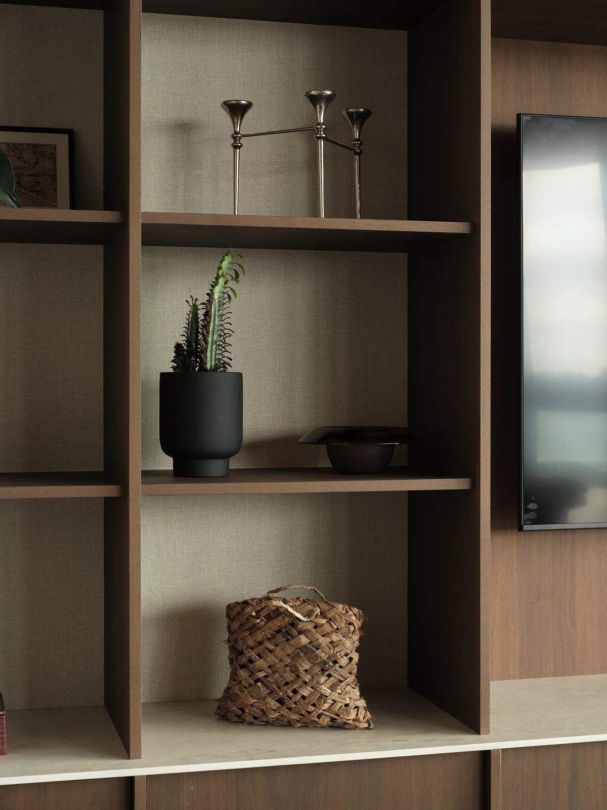 Soft morning light on the display shelves, candlesticks and objects beside the television