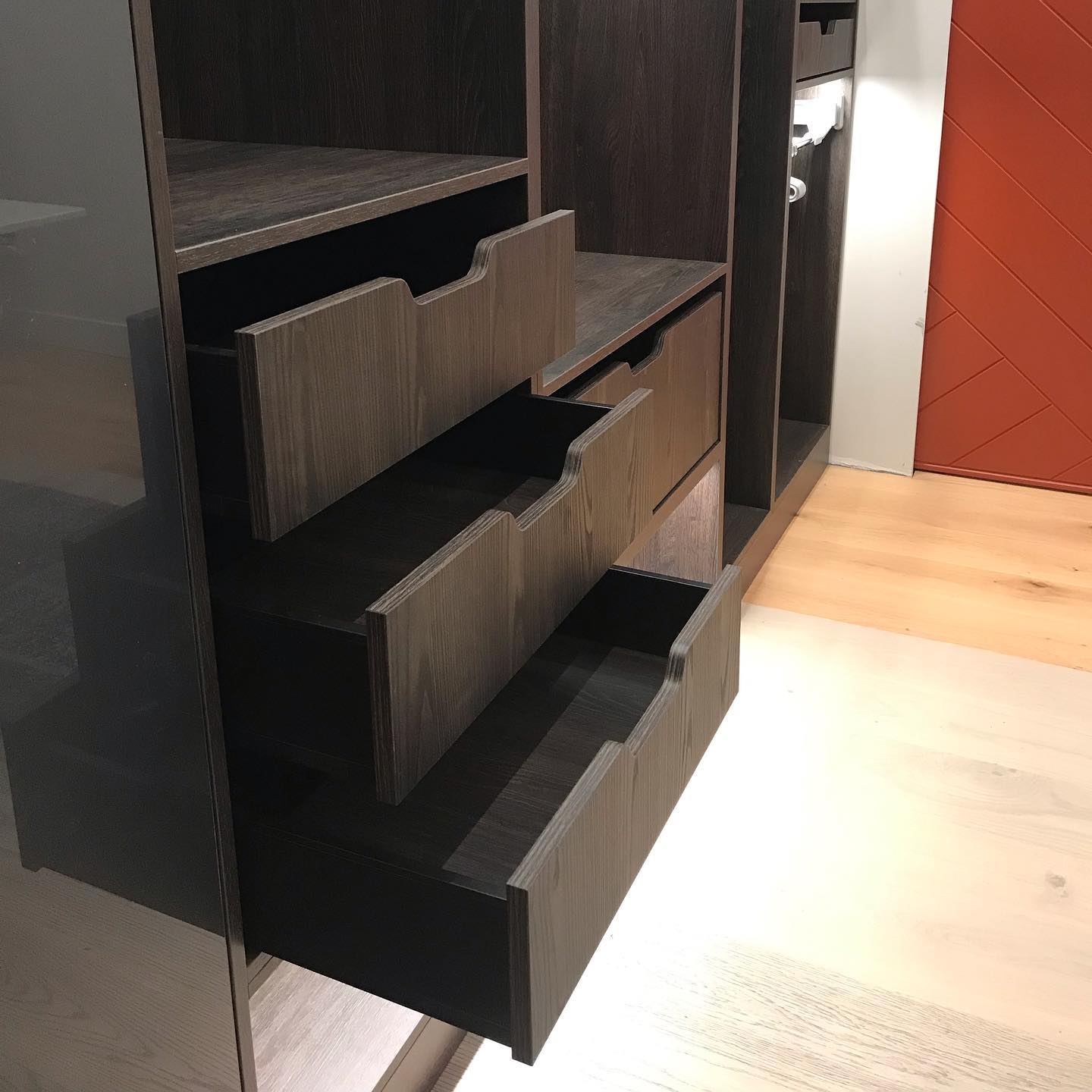 Custom wardrobe drawers open to show shaped timber fronts and fitted internal storage