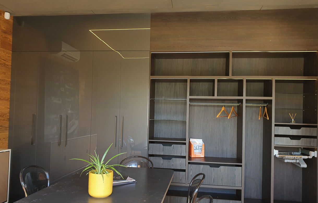Full showroom wardrobe display with gloss full-height cupboards, hanging space, shelves and drawers