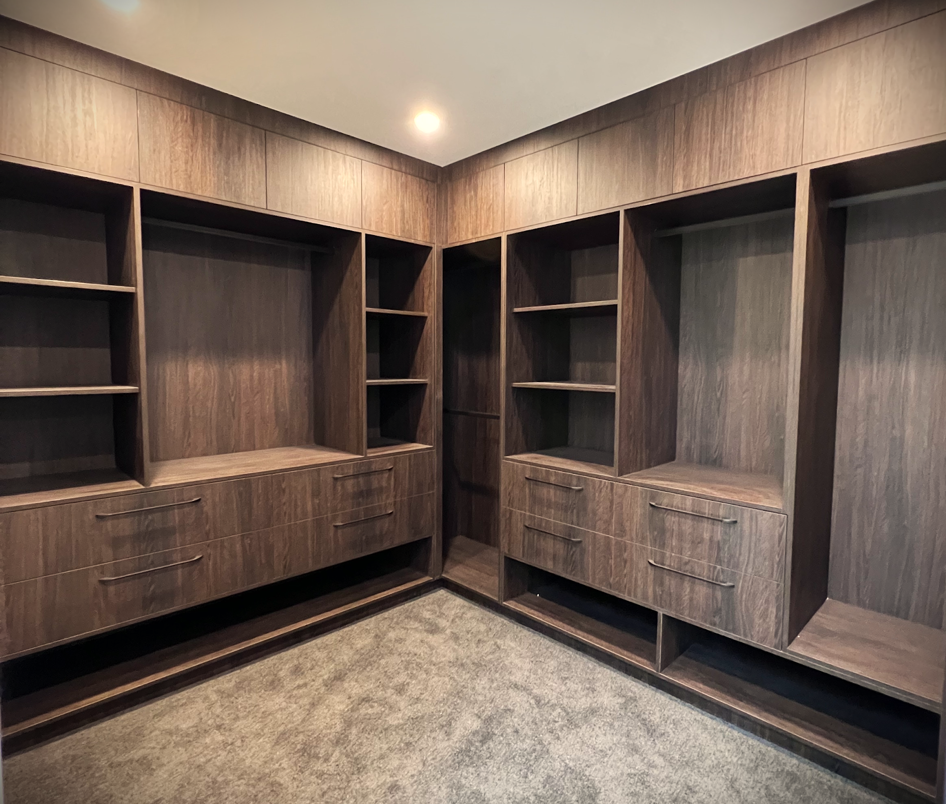 Custom timber walk-in wardrobe fitted wall to wall with hanging space, drawers and open shelving