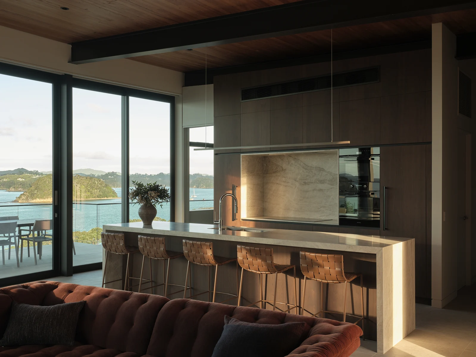 Afternoon view across the sofa towards the walnut kitchen, stone island and bay