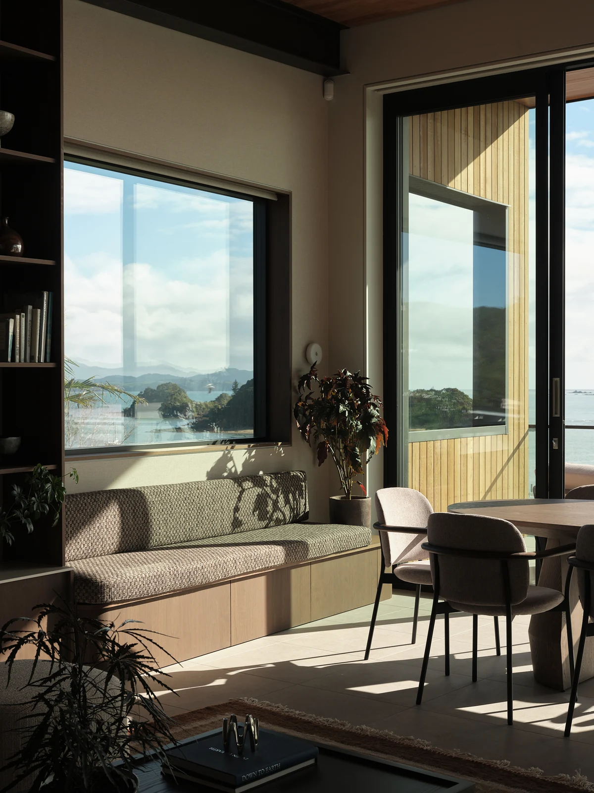 A long upholstered window seat overlooking the bay beside the dining table